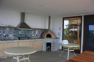 cocina con mesa y chimenea en Tavarua Itacimirim Hirata, en Camaçari