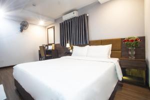 una camera con un grande letto bianco e una scrivania di LEE HOTEL ad Ho Chi Minh