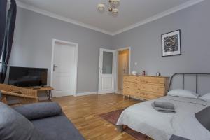 Sala de estar con cama y TV en CR Apartament w Śródmieściu Sienkiewicza 1, en Białystok