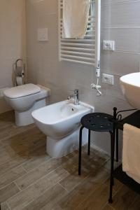 a white bathroom with a sink and a toilet at Casa Concerie Quattro in Sulmona