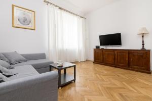 een woonkamer met een bank en een flatscreen-tv bij Powiśle Superior Apartment in Warschau