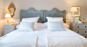 a bedroom with a white bed with blue and white pillows at La Casa de los Tomillares in Candeleda