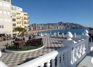 - un balcon avec une promenade à côté de l'eau dans l'établissement Apartamento en el centro a un minuto de la playa, à Benidorm