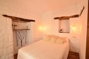 um quarto branco com uma cama com 2 almofadas em Casa Moraleda em Benalauría