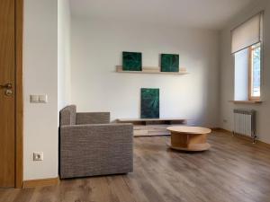 a living room with a chair and a table at Сhocolate Factory Apartment Nr.2 in Riga