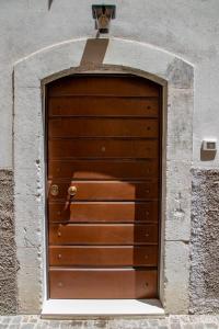 a wooden garage door in a stone wall at Casa Concerie Due in Sulmona