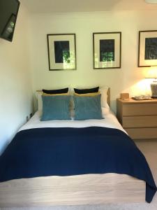 a bedroom with a blue and white bed and a table at Garden Room in Wallingford