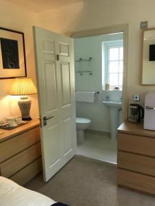 a bedroom with a bathroom with a toilet and a sink at Garden Room in Wallingford