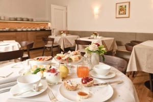 a table with plates of food on it in a restaurant at Ansitz Punthof in Lagundo