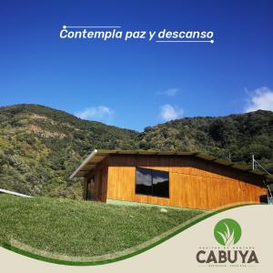 a house with a grass roof on a hill at Casitas de Montaña Cabuya in Monteverde Costa Rica
