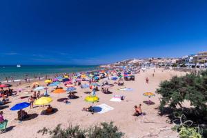 a crowd of people on a beach with umbrellas at A casa di Vale in Cava D'aliga