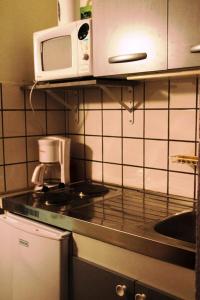 eine Küche mit einer Arbeitsplatte und einer Mikrowelle in der Unterkunft Studio au pied des pistes + Cellier in La Mongie