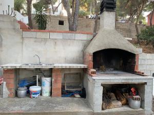 una cocina al aire libre con fregadero y un horno de ladrillo en Casa Portopino, en Porto Pino