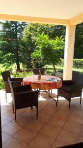 un patio con mesa y sillas en un porche en Apartment Neda Z-velika okućnica, besplatni parking i optički wi-fi, en Labin