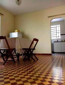 uma cozinha com uma mesa e duas cadeiras num quarto em Quinta dos Paiva: horta natural e sossego em Monte Alegre do Sul