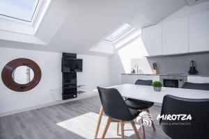 a white kitchen with a table and chairs at MIROTZA ROOMS AND APARTMENTS in Orio