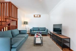 sala de estar con sofás azules y TV en 1 CHARMING VILLA Private Garden Pool, Bbq! en Adeje