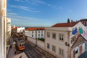 Una vista de una ciudad con un tren en una calle. en Gonzalos's Guest Apartments - Alfama Terrace, en Lisboa