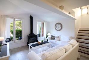 a living room with a white couch and a fireplace at Gorgeous renovated Cala Sant Vicenc Beach Villa in Cala de Sant Vicenc
