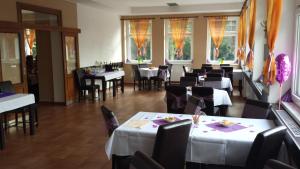 jadalnia z białymi stołami i krzesłami w obiekcie Restaurace a penzion Zděná Bouda w mieście Hradec Králové