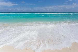a sandy beach with the ocean and blue water at Large House - walking to beach - 10 guests! in Cancún