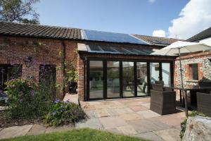 an extension to a brick house with a patio at Southrepps BarnHam in Cromer