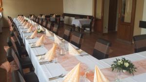 a long table in a room with tables and chairs at Restaurace a penzion Zděná Bouda in Hradec Králové