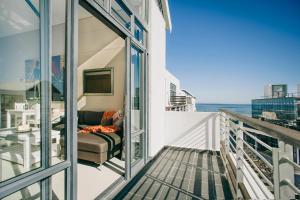 a balcony with a couch and a view of the ocean at Eden on the bay 217A-Penthouse in Cape Town