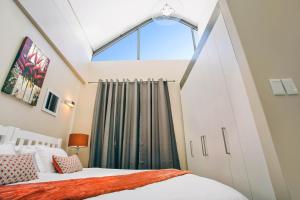 a bedroom with a bed and a window at Eden on the bay 217A-Penthouse in Cape Town