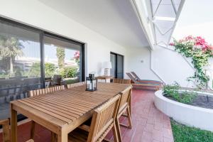 a wooden table and chairs on a patio at Victory Village 1B Quinta do Lago in Quinta do Lago