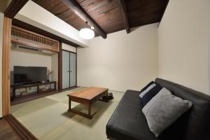 un soggiorno con divano nero e tavolo di Kyoto - House / Vacation STAY 43525 a Kyoto