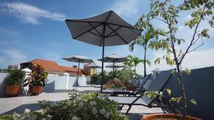 eine Terrasse mit einem Tisch und einem Sonnenschirm in der Unterkunft Hotel Casa Cytia in Cartagena de Indias