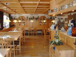 um restaurante com pisos e mesas e cadeiras de madeira em Hotel Pension Fleischmann em Roding