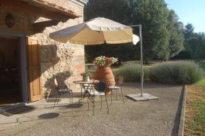 a table and chairs under an umbrella in a patio at Fattoria Antognoni in Reggello
