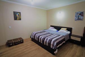 ein Schlafzimmer mit einem Bett mit einer gestreiften Decke in der Unterkunft cozy and warm in Tbilisi City