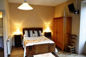 ein Schlafzimmer mit einem Bett, einer Kommode und zwei Lampen in der Unterkunft Les gîtes du bourg in Vitrac