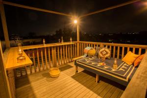 una terrazza con panchina e tavolo sul balcone di notte di Okinawa - House / Vacation STAY 44500 a Città di Okinawa
