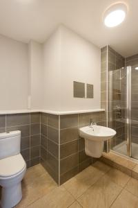 a bathroom with a toilet and a shower and a sink at City Retreat Edinburgh ApartHotels in Edinburgh +37 photos