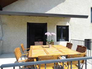 a wooden table and chairs on a patio at Les violettes du Bugey in Marchamp