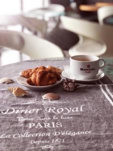 a table with a cup of coffee and a plate of pastries at Friday Hotel in Mamaia Nord