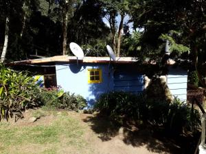uma casa azul e branca com duas borboletas no telhado em Chales Bamboo Jungle em Petrópolis