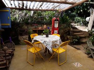 uma mesa com cadeiras amarelas e um posto de gasolina em Chales Bamboo Jungle em Petrópolis