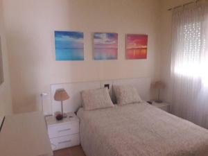1 dormitorio con 1 cama y 3 cuadros en la pared en Apartamento en rota, en Rota