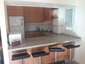 una cocina con encimera con taburetes. en Apartamento en rota, en Rota