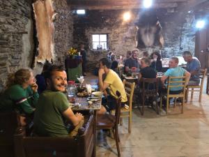 a group of people sitting at tables in a restaurant at Raul Lushnu Darbaz in Mestia
