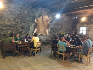a group of people sitting at tables in a restaurant at Raul Lushnu Darbaz in Mestia