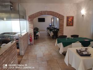 a restaurant with tables and chairs in a room at Hotel-Locanda ZANZARINA D'ORO nel PARCO OGLIO SUD in Calvatone