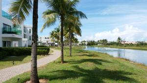un chemin à côté d'une rivière bordée de palmiers dans l'établissement AP. DE LUXO NO IBEROSTATE, à Praia do Forte