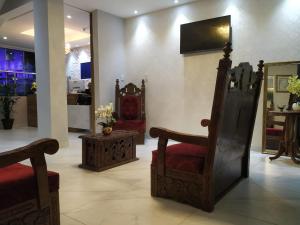 um quarto com duas cadeiras e uma televisão na parede em Palace Hotel Pôr do Sol em Vitória da Conquista