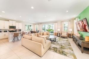 un ampio soggiorno con divani e cucina di Modern Home by Rentyl with Private Pool, Water Park and Resort Amenities - 301B a Orlando